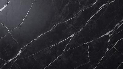 The primary subject of the image is a black marble countertop. The setting is a kitchen, with the countertop being the main focus of the scene. The visual style is a close-up of the marble countertop, showcasing its texture and pattern. The colors and mood of the image are predominantly dark, with the black marble countertop being the main source of contrast.
