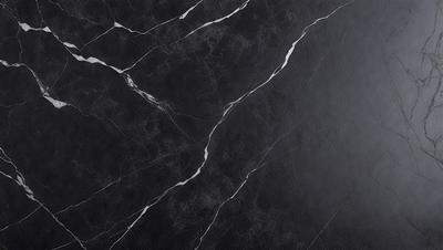 The image features a black marble countertop with a white vein running through it. The countertop appears to be a part of a kitchen or bathroom setting. The black and white color scheme creates a striking contrast, giving the countertop a modern and elegant appearance.