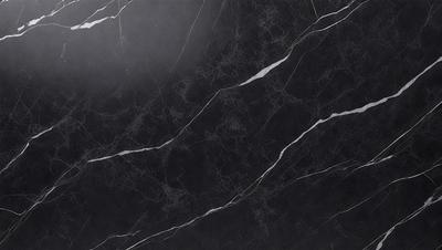 The primary subject of the image is a black marble countertop. The setting is a kitchen, with the countertop being the main focus of the scene. The visual style is a close-up of the marble countertop, showcasing its texture and pattern. The colors and mood of the image are predominantly dark, with the black marble countertop being the main source of contrast.