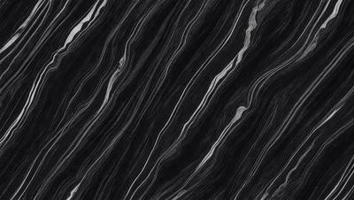 The primary subject of the image is a black and white patterned surface, which appears to be a marble or stone texture. The setting is a dark background, which contrasts with the patterned surface. The visual style is a close-up of the pattern, showcasing the intricate details of the design. The colors and mood of the image are predominantly dark, with the black and white pattern creating a sense of depth and contrast.