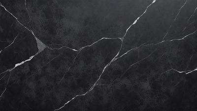 The primary subject of the image is a close-up of a black marble countertop. The setting is a kitchen, with the marble countertop being the main focus of the scene. The visual style is a photo, capturing the details of the marble surface. The colors and mood of the image are predominantly dark, with the black marble countertop being the main source of contrast.