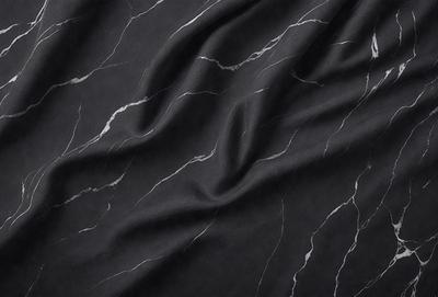 The primary subject of the image is a black marble countertop. The setting is a kitchen, with the countertop being the main focus of the scene. The visual style is a close-up of the marble countertop, showcasing its texture and pattern. The colors and mood of the image are predominantly black, giving it a sleek and modern appearance.