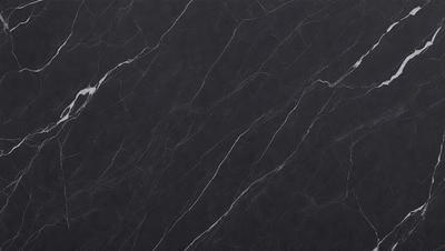 The primary subject of the image is a black marble countertop. The setting is a kitchen, with the countertop being the main focus of the scene. The visual style is a close-up of the marble countertop, showcasing its texture and pattern. The colors and mood of the image are predominantly dark, with the black marble countertop being the main source of contrast.