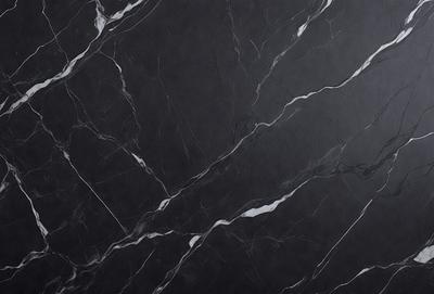 The primary subject of the image is a black marble countertop. The setting is a kitchen, with the countertop being the main focus of the scene. The visual style is a close-up of the marble countertop, showcasing its texture and pattern. The colors and mood of the image are predominantly dark, with the black marble countertop being the main source of contrast.