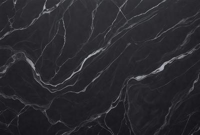 The primary subject of the image is a black marble countertop. The setting is a kitchen, with the countertop being the main focus of the scene. The visual style is a close-up of the marble countertop, showcasing its texture and pattern. The colors and mood of the image are predominantly dark, with the black marble countertop being the main source of contrast and visual interest.