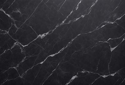 The primary subject of the image is a black marble countertop. The setting is a kitchen, with the countertop being the main focus of the scene. The visual style is a close-up of the marble countertop, showcasing its texture and pattern. The colors and mood of the image are predominantly dark, with the black marble countertop being the main source of contrast.