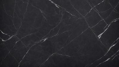 The primary subject of the image is a black marble countertop. The setting is a kitchen, with the countertop being the main focus of the scene. The visual style is a close-up of the marble countertop, showcasing its texture and pattern. The colors and mood of the image are predominantly dark, with the black marble countertop being the main source of contrast.