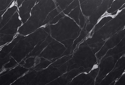The primary subject of the image is a black marble countertop. The setting is a kitchen, with the countertop being the main focus of the scene. The visual style is a close-up of the marble countertop, showcasing its texture and pattern. The colors and mood of the image are predominantly dark, with the black marble countertop being the main source of contrast.