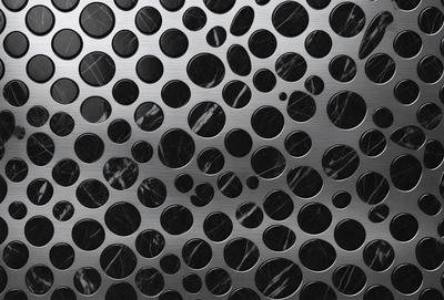 The primary subject of the image is a pattern of circles on a surface. The setting is a black and white background, which gives the image a classic and timeless appearance. The visual style is a combination of a photo and digital art, creating a unique and intriguing pattern. The dominant colors are black and white, which contribute to the overall mood of the image, evoking a sense of elegance and sophistication.