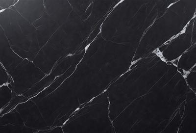 The primary subject of the image is a black marble countertop. The setting is a kitchen, with the countertop being the main focus of the scene. The visual style is a close-up of the marble countertop, showcasing its texture and pattern. The colors and mood of the image are predominantly dark, with the black marble countertop being the main source of contrast.