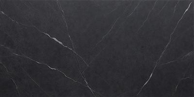 The primary subject of the image is a black marble countertop. The setting is a kitchen, with the countertop being the main focus of the scene. The visual style is a close-up of the marble countertop, showcasing its texture and details. The colors and mood of the image are predominantly dark, with the black marble countertop being the main source of contrast and visual interest.