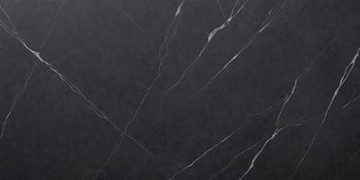 The primary subject of the image is a close-up of a marble countertop. The setting is a kitchen, with the countertop being the main focus of the scene. The visual style is a photo, capturing the natural texture and beauty of the marble surface. The colors and mood of the image are predominantly dark, with the marble countertop being the main source of light and contrast.