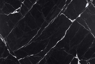 The primary subject of the image is a black marble countertop. The setting is a kitchen, with the countertop being the main focus of the scene. The visual style is a close-up of the marble countertop, showcasing its texture and pattern. The colors and mood of the image are predominantly dark, with the black marble countertop being the main source of contrast.