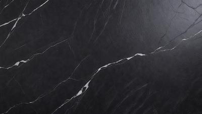 The primary subject of the image is a black marble countertop. The setting is a kitchen, with the countertop being the main focus of the scene. The visual style is a close-up of the marble countertop, showcasing its texture and details. The colors and mood of the image are predominantly dark, with the black marble countertop being the main source of contrast and visual interest.