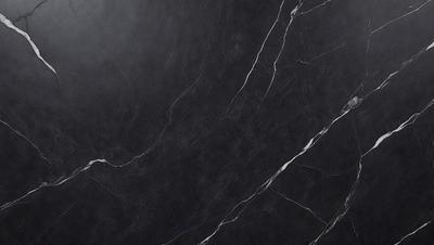 The primary subject of the image is a black marble countertop. The setting is a kitchen, with the countertop being the main focus of the scene. The visual style is a close-up of the marble countertop, showcasing its texture and details. The colors and mood of the image are predominantly dark, with the black marble countertop being the main source of contrast and visual interest.