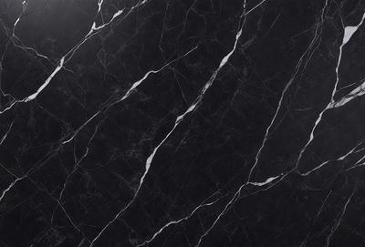 The primary subject of the image is a black marble countertop. The setting is a kitchen, with the countertop being the main focus of the scene. The visual style is a close-up of the marble countertop, showcasing its texture and pattern. The colors and mood of the image are predominantly dark, with the black marble countertop being the main source of contrast.