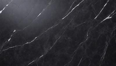 The primary subject of the image is a close-up of a marble countertop. The setting is a kitchen, with the countertop being the main focus of the scene. The visual style is a photo, capturing the natural texture and beauty of the marble surface. The colors and mood of the image are predominantly black and white, giving it a classic and elegant appearance.