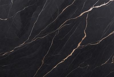 The primary subject of the image is a close-up of a black marble countertop. The setting is a kitchen, with the countertop being the main focus of the scene. The visual style is a photo, capturing the intricate details of the marble surface. The colors and mood of the image are predominantly dark, with the black marble providing a striking contrast against the surrounding environment.