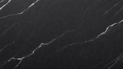 The primary subject of the image is a black marble countertop. The setting is a kitchen, with the countertop being the main focus of the scene. The visual style is a close-up of the marble countertop, showcasing its texture and details. The colors and mood of the image are predominantly dark, with the black marble countertop being the main source of contrast and visual interest.