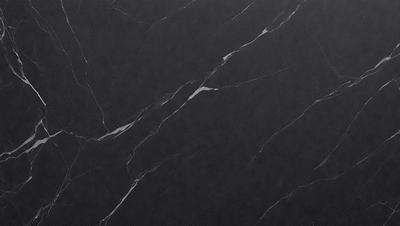 The primary subject of the image is a black marble countertop. The setting is a kitchen, with the countertop being the main focus of the scene. The visual style is a close-up of the marble countertop, showcasing its texture and pattern. The colors and mood of the image are predominantly dark, with the black marble providing a striking contrast against the darker background.