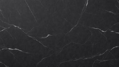 The primary subject of the image is a black marble countertop. The setting is a kitchen, with the countertop being the main focus of the scene. The visual style is a close-up of the marble countertop, showcasing its texture and pattern. The colors and mood of the image are predominantly dark, with the black marble countertop being the main source of contrast and visual interest.