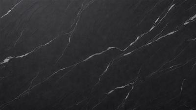 The primary subject of the image is a black marble countertop. The setting is a kitchen, with the countertop being the main focus of the scene. The visual style is a close-up of the marble countertop, showcasing its texture and pattern. The colors and mood of the image are predominantly dark, with the black marble countertop being the main source of contrast.
