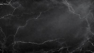 The primary subject of the image is a black and white photo of a marble surface. The setting is a dark room, and the visual style is a close-up of the marble surface. The colors and mood of the image are predominantly dark and moody, with the marble surface being the main focus.