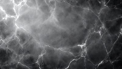 The image is a black and white photo of a marble wall. The wall is covered in a pattern of white and grey veins, giving it a unique and textured appearance. The overall atmosphere of the image is elegant and sophisticated, with the marble wall serving as a striking backdrop.