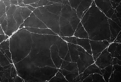 The primary subject of the image is a black and white marble wall. The setting is a dark room, and the visual style is a close-up of the marble wall. The colors and mood of the image are predominantly dark and moody, with the marble wall being the main focus.