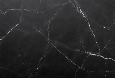 The primary subject of the image is a marble countertop with a black background. The countertop has a patterned texture, giving it a unique and elegant appearance. The visual style of the image is a close-up of the marble countertop, showcasing its intricate details. The colors and mood of the image are predominantly black, giving it a sophisticated and timeless feel.
