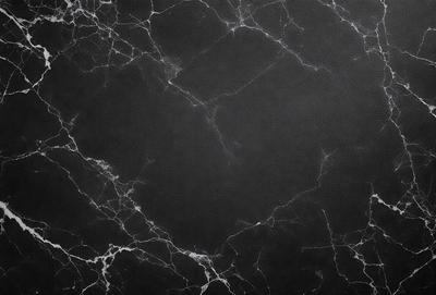 The primary subject of the image is a black marble countertop. The setting is a dark room, and the visual style is a close-up of the marble countertop. The countertop has a black and white pattern, and the overall atmosphere is dark and moody.