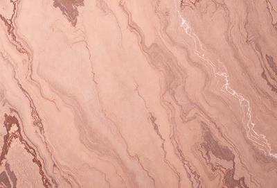 The primary subject of the image is a marble-like surface with a pattern of swirls and waves. The setting is a room with a brown color scheme. The visual style is a close-up of the marble-like surface, which gives it a natural and textured appearance. The colors and mood of the image are warm and earthy, with the brown marble-like surface being the dominant color.