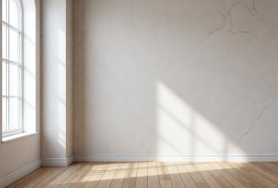 The primary subject of the image is a white wall with a marble texture. The setting is a room with a wooden floor. The visual style is a photo, and the colors and mood are predominantly white, giving the room a clean and minimalist appearance.