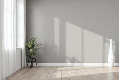 The primary subject of the image is a potted plant placed on a wooden floor. The plant is situated in front of a wall, which appears to be a blank canvas. The setting is indoors, with the plant being the main focus of the scene. The visual style of the image is a photo, capturing the plant and its surroundings in a realistic manner. The colors and mood of the image are predominantly neutral, with the wooden floor and the plant providing a sense of warmth and natural beauty.