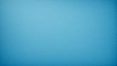 The primary subject of the image is a large, open, and empty blue sky. The setting is a vast, cloudless expanse, with no visible landmarks or objects. The visual style is a natural, untouched landscape, with no indication of digital manipulation or artistic elements. The colors and mood are predominantly blue, creating a serene and tranquil atmosphere.