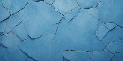 The primary subject of the image is a blue wall with a cracked and chipped appearance. The setting is a room with a blue background. The visual style is a photo, and the dominant colors are blue and white. The overall atmosphere is somewhat rough and unpolished, giving the impression of a worn or aged surface.