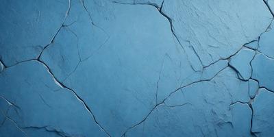 The primary subject of the image is a blue wall with a cracked and chipped appearance. The setting is a room with a blue background. The visual style is a close-up of the blue wall, showcasing its texture and imperfections. The colors and mood of the image are predominantly blue, giving it a calm and serene atmosphere.