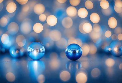 The primary subject of the image is a pair of blue glass balls. They are placed on a blue surface, which could be a table or a floor. The setting appears to be indoors, with a blue background that complements the blue glass balls. The visual style of the image is a close-up, focusing on the two blue glass balls. The colors and mood of the image are predominantly blue, creating a calm and serene atmosphere.