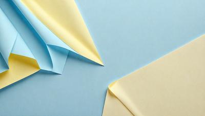 The primary subject of the image is a blue background with a yellow and blue paper. The paper is folded into a triangle shape, creating a visually interesting and colorful display. The setting appears to be a table or a flat surface where the paper is placed. The visual style of the image is a combination of digital art and illustration, as the paper is carefully crafted and the colors are vibrant. The overall atmosphere of the image is lively and engaging, with the blue and yellow colors creating a sense of energy and