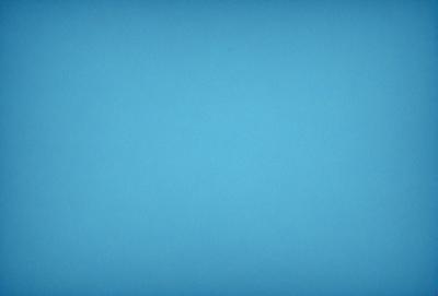The primary subject of the image is a large, open, and empty blue sky. The setting is a vast, cloudless expanse, with no visible landmarks or objects. The visual style is a natural, untouched landscape, with no indication of digital manipulation or artistic elements. The colors and mood are predominantly blue, conveying a sense of tranquility and vastness.