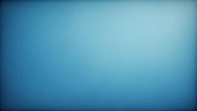 The primary subject of the image is a large, empty blue sky. The setting is a vast, open space with no visible landmarks or objects. The visual style is a natural, outdoor scene with a focus on the sky. The colors and mood are predominantly blue, creating a calm and serene atmosphere.