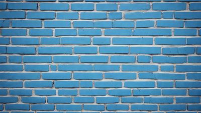 The primary subject of the image is a blue brick wall. The setting is a brick wall with a blue color, and the visual style is a photo. The colors and mood of the image are predominantly blue, creating a calm and serene atmosphere.
