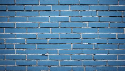 The primary subject of the image is a blue brick wall. The setting is a brick wall, and the visual style is a photo. The dominant colors are blue and white, creating a calm and serene atmosphere.