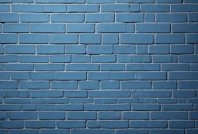 The primary subject of the image is a blue brick wall. The setting is a brick wall, and the visual style is a photo. The dominant colors are blue and white, creating a calm and serene atmosphere.