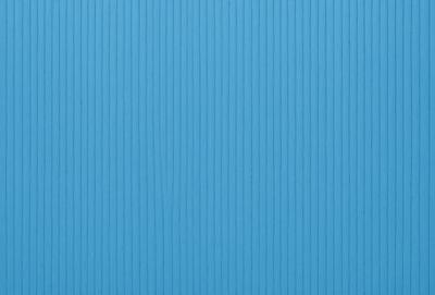 The primary subject of the image is a blue wall with a wooden texture. The setting is a room with a blue wall, and the visual style is a photo. The dominant colors are blue and white, creating a calm and serene atmosphere.