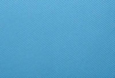 The primary subject of the image is a blue surface with a pattern of white stripes. The setting appears to be a room with a blue wall, and the visual style is a close-up of the blue surface. The colors and mood of the image are predominantly blue and white, creating a calm and serene atmosphere.