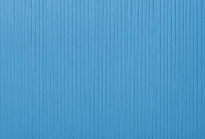 The primary subject of the image is a blue wall with a wooden texture. The setting is a room with a blue wall, and the visual style is a photo. The dominant colors are blue and white, creating a calm and serene atmosphere.