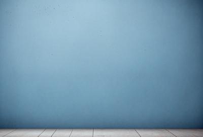 The primary subject of the image is a blue wall with a wooden floor. The setting is a room with a blue wall, and the visual style is a photo. The dominant colors are blue and white, creating a calm and serene atmosphere.