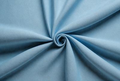 The primary subject of the image is a blue fabric, possibly a piece of cloth or a curtain. The setting is a blue background, which creates a contrast with the fabric. The visual style appears to be a close-up of the fabric, showcasing its texture and details. The colors and mood of the image are predominantly blue, giving it a calm and serene atmosphere.