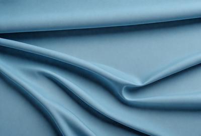 The primary subject of the image is a blue fabric, which is the main object, scene, or focus of the image. The setting or background is a blue surface, which adds to the overall atmosphere. The visual style of the image is a close-up of the blue fabric, showcasing its texture and details. The colors and mood of the image are predominantly blue, creating a calm and serene atmosphere.